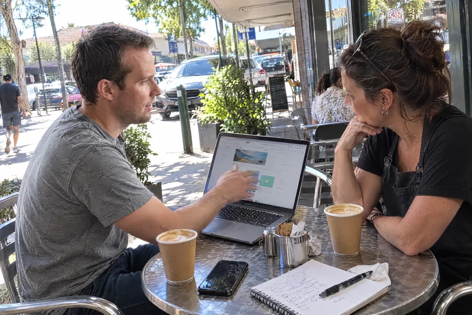 Dru showing a website design to a local cafe owner over coffee