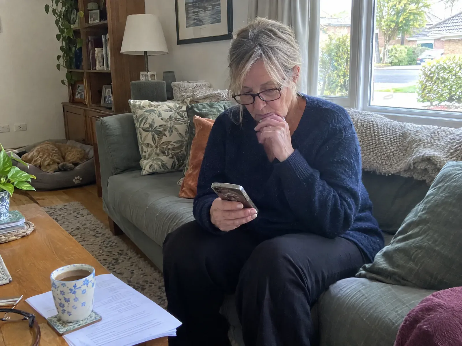 A patient at home reading about her upcoming surgery on her phone